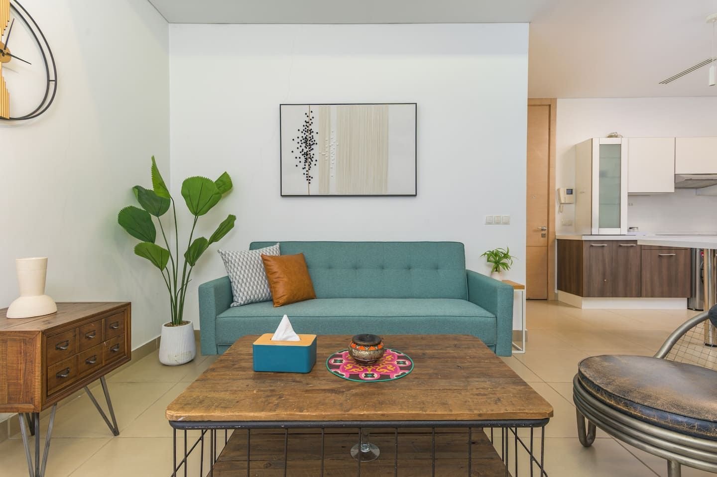 Living room with teal sofa, Downtown Saifi 1-Bedroom with Pool & Bathtub